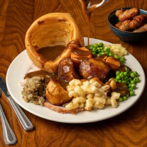 A Toby Carvery Roast Dinner of Potatoes , stuffing, yorkshire pudding, mac & cheese , peas and gravy